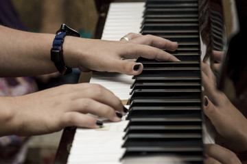 Fototapeta na wymiar Manos de mujer tocando el piano. Reproducción de música por un pianista. Manos en el piano.