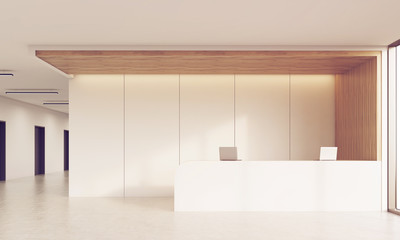 Front view of sunlit reception desk in corridor