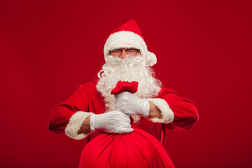 santa claus with big bag on shoulder glasses  red background