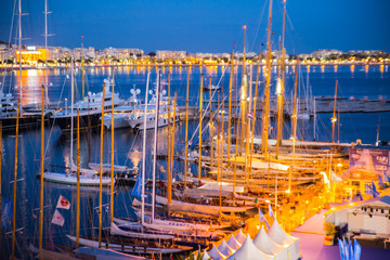 Old Port Vieux Port in the city of Cannes at night. Lots of sailing boats and power yachts anchored during the Sailing regatta. 