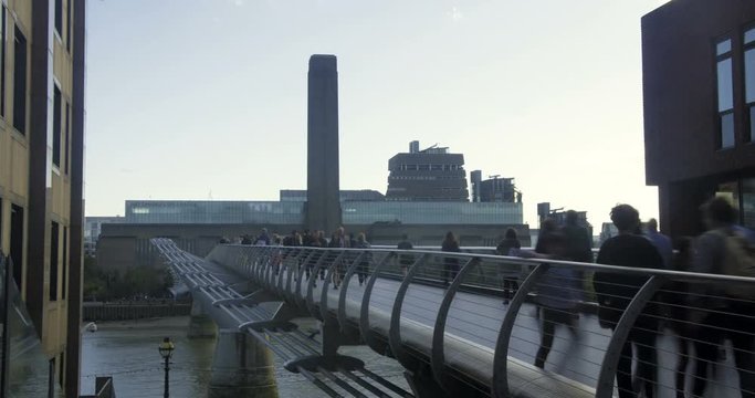 Time lapse view of people crossing the Millennium bridge in London with the Tate modern in the background