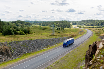 blue truck on a highway carries the cargo van