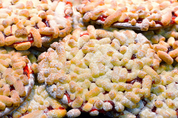 Round cookies sprinkled with short cylinder of dough and jam