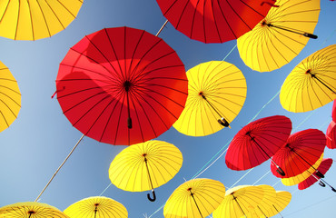colorful yellow and red  umbrellas under the beautiful cloudy sky