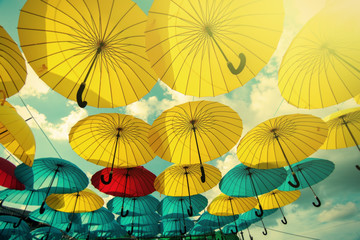 Fototapeta na wymiar colorful yellow, red and blue umbrellas under the beautiful cloudy sky