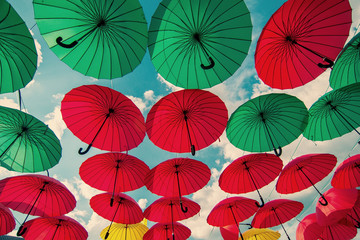 Fototapeta na wymiar colorful green , red and yellow umbrellas under the beautiful cloudy sky
