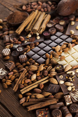 Chocolate bars and pralines on wooden background