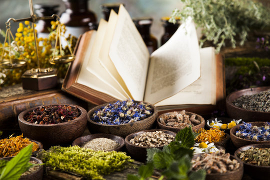 Book and Herbal medicine on wooden table background