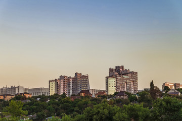 Fototapeta na wymiar Neighborhood of low-rise residential buildings with multi-storey buildings on a steep slope. Evening skyline. City Belgorod, Russia.