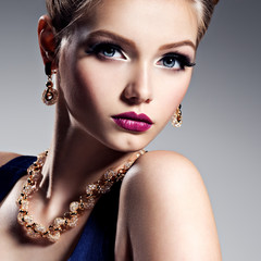 Pretty girl with beautiful gold jewelry and bright make-up