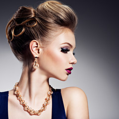Beautiful woman with style hairstyle  and gold jewelry with brig