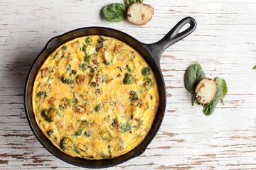Acrylic prints Fried eggs Baked egg frittata with spinach, cheese, broccoli, red potatoes, bacon, milk, and spinach far away shot from top