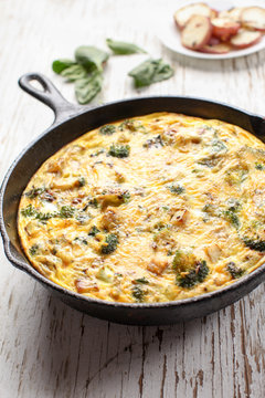 Baked egg frittata with spinach, cheese, broccoli, red potatoes, bacon, milk, and spinach angled view