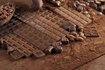 Dark homemade chocolate bars and cocoa pod on wooden