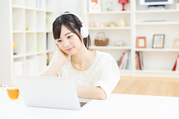 attractive asian woman using laptop computer
 in the living room