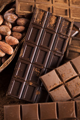 Dark homemade chocolate bars and cocoa pod on wooden