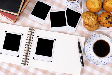 Photo album on a desk or table with two polaroid style photo print frame side by side and afternnon tea holiday vacation wedding memories