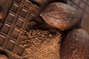 Chocolate bar, candy sweet, cacao beans and powder on wooden bac