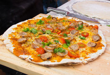 delicious homemade pizza with sausage ham and cheese on a wooden
