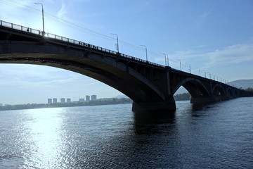 Naklejka na ściany i meble cityscape with bridge on the river at dawn, backlight