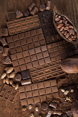 Dark homemade chocolate bars and cocoa pod on wooden