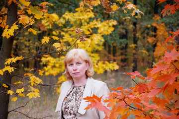 Naklejka na ściany i meble Mature caucasian woman in the autumn park