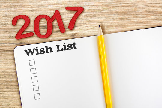 Top view of 2017 wish list red number with blank open notebook a