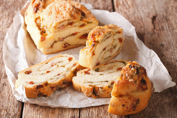 Delicious bread with cheese, bacon and dried tomatoes close-up. horizontal
