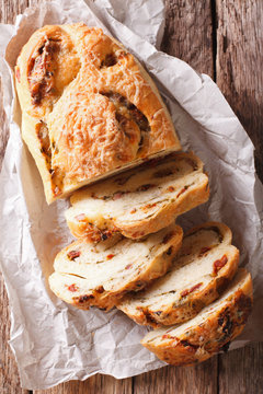 Delicious bread with cheese, bacon and dried tomatoes close-up. vertical top view
