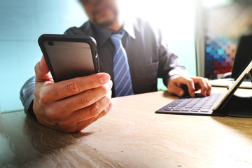 businessman using smart phone and keyboard dock digital tablet.W