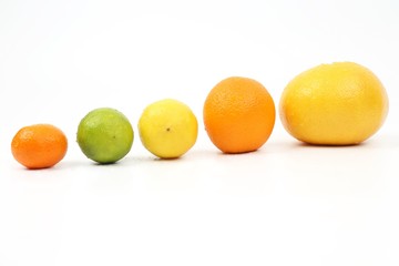 citrus fruits lie on an incline on a white background