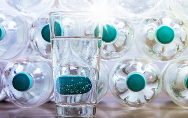 viele Flaschen mit Mineralwasser und ein Glas