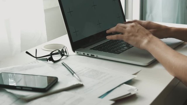 Woman working on laptop at home interier near the window. Hands and fingers on the keyboard close-up