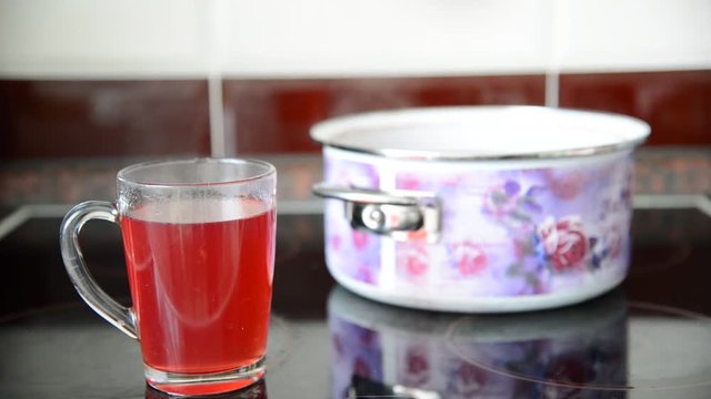 cup of hot compote and pan stand on the plate