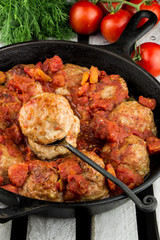 Homemade turkey meatballs. Cutlets in the pan. Tomato sauce. Rustic style.