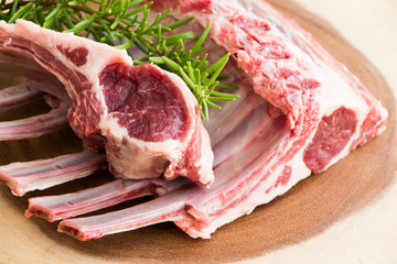 Raw meat. Lamb ribs. Fresh lamb ribs on the cutting board. Raw meat with rosemary.