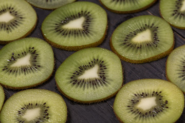 fresh kiwi lay on black wood table