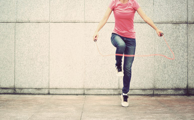 young fitness woman jumping rope outdoor