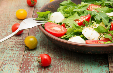 Green salad made with arugula, tomatoes, cheese mozzarella balls