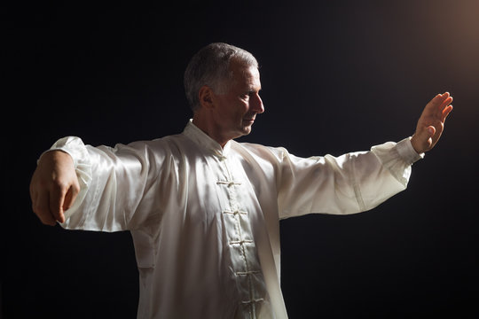 Senior Man Enjoys Exercise Tai Chi Indoor.