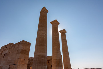 3 ancient pillars in front of the sun