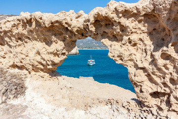 Hole in Rocks with Fishing boat in backround