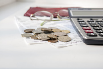 Several small rubles lie on checks on the background of a calculator and glasses