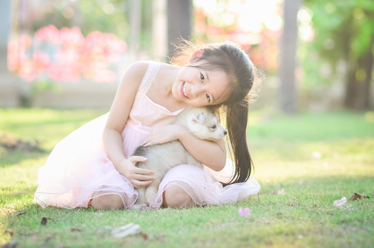 sian girl playing with siberian husky puppy