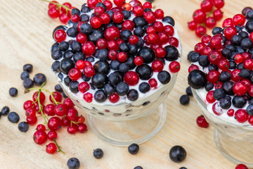 Dessert with cream and fresh berries (red and black currants, blueberry)
