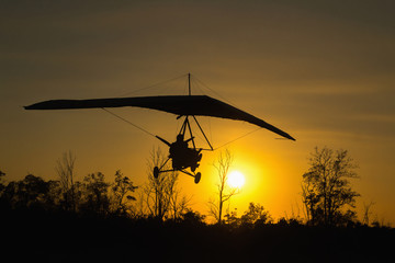 Man on hang glider land at sunset