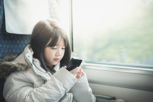 Little asian girl sharing social media in a smart phone