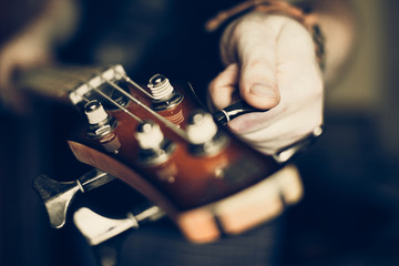 Musician playing electric bass guitar, hands in focus