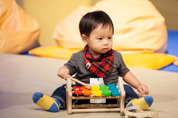 little boy playing by xylophone