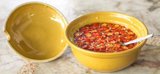 Chili and fish sauce mixed in yellow cup for seasoning thaifood